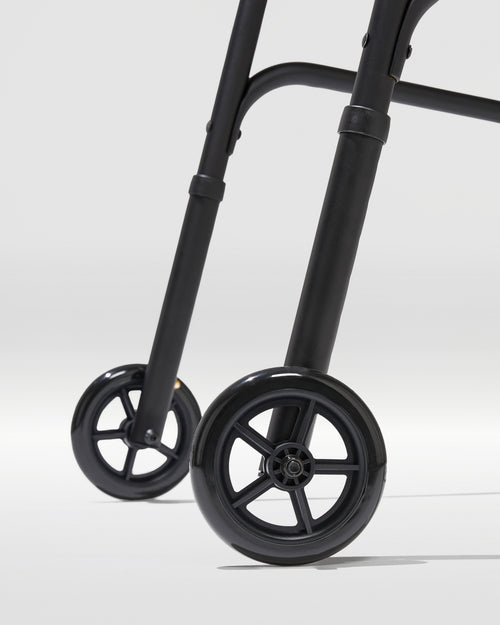 Close-up of a black walker with wheels on a light gray background