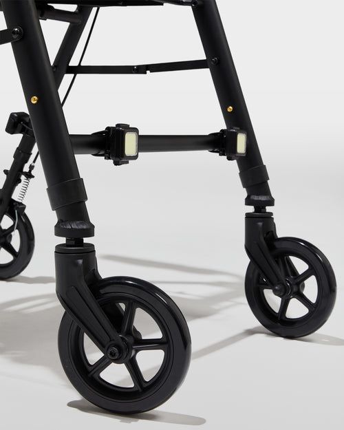 Close-up of a black walker with wheels on a light gray background