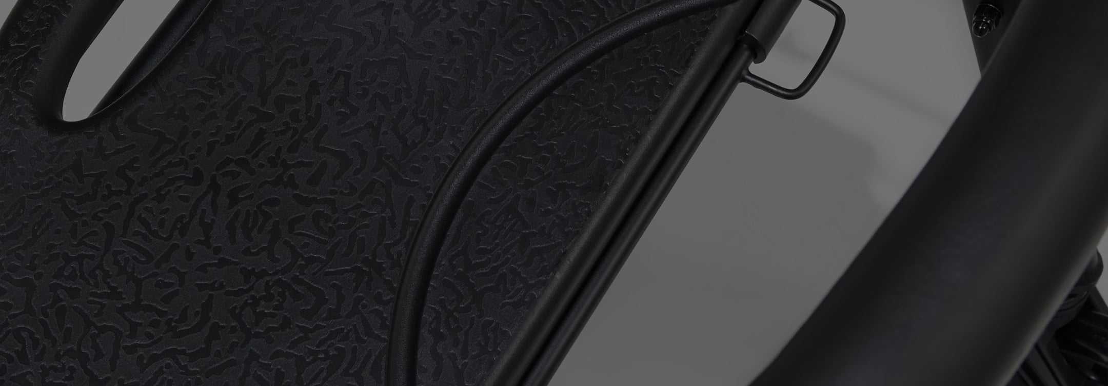 Close-up of a textured black surface with a cable running through it