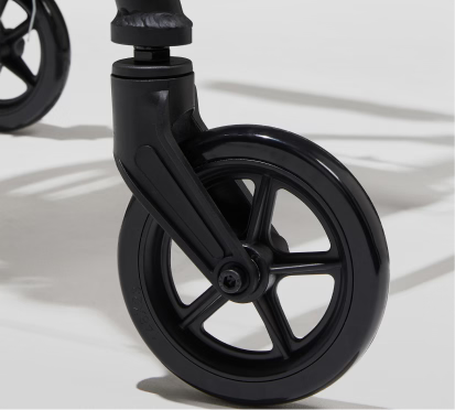 Close-up of a black scooter wheel on a light background