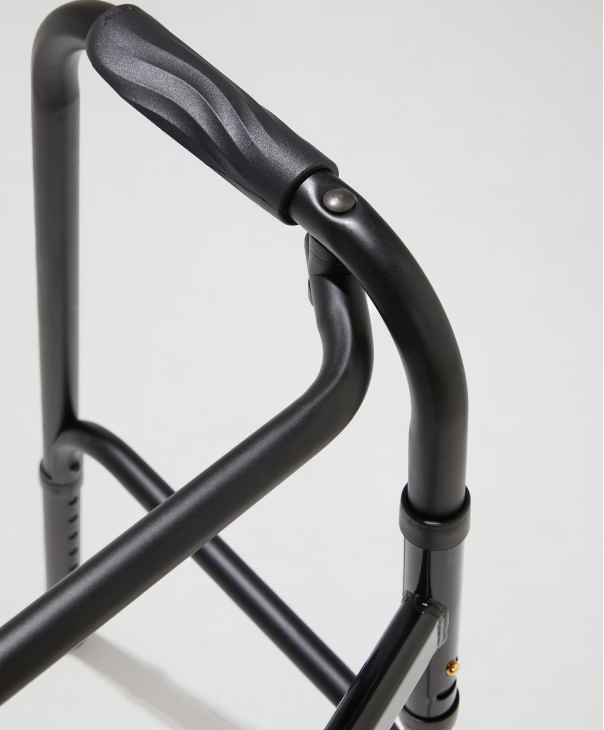 Close-up of a black walker frame on a white background