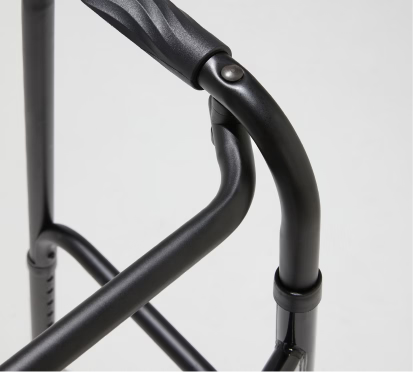Close-up of a black walker frame on a light gray background